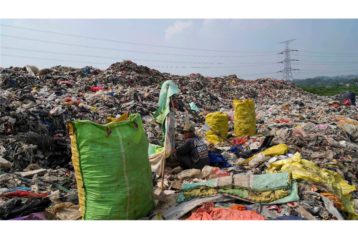 Einblick in die Umweltverschmutzung der Erde: In der Deponie in Depok am Rande von Jakarta türmt sich der Müll. Für diesen Lumpensammler, der sich ausruht, gehört der Anblick zum Alltag.