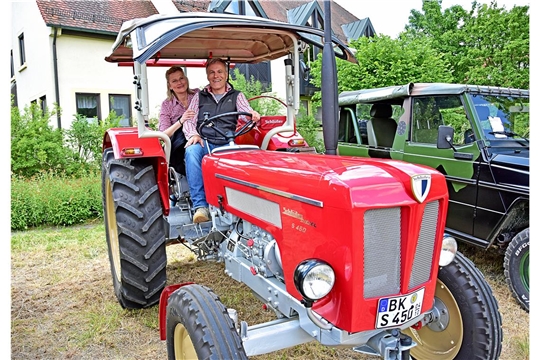 Michael Wächter aus Allmersbach im Tal und seine Ehefrau auf einem feuerroten SchlütterTraktor. 