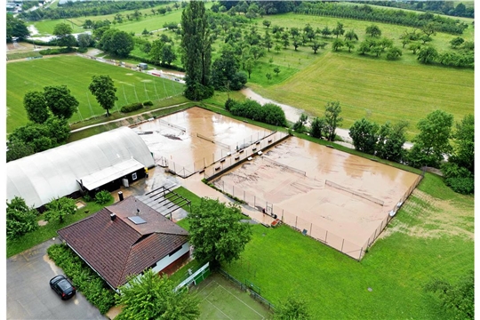 Wasser und Schlamm steht auf den Tennisplätzen. 