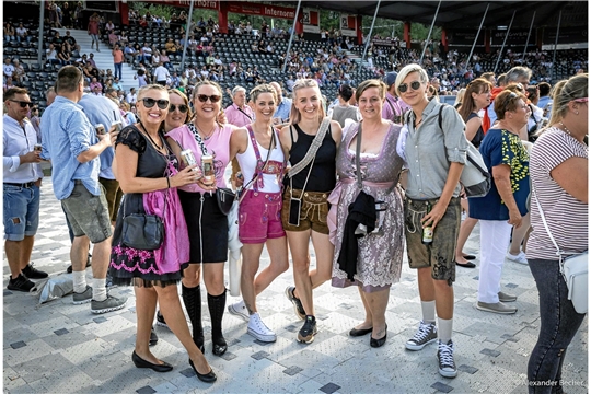 Frauen in Dirndl und Lederhosen freuen sich auf das Konzert, bei dem der Spaßfaktor garantiert ist.