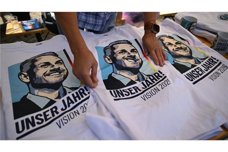  T-Shirts mit dem Portrait des AfD Spitzenkandidaten Ulrich Siegmund liegen an einem Wahlkampfstand der AfD auf dem Marktplatz in Zeitz. Die Sachsen-Anhalter wählen am 06. September einen neuen Landtag.