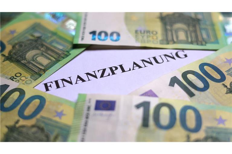 100-Euro-Banknoten liegen um das Wort «Finanzplanung». (zu dpa: «Kommunen erhöhen vor Finanzverhandlungen Druck auf das Land»)