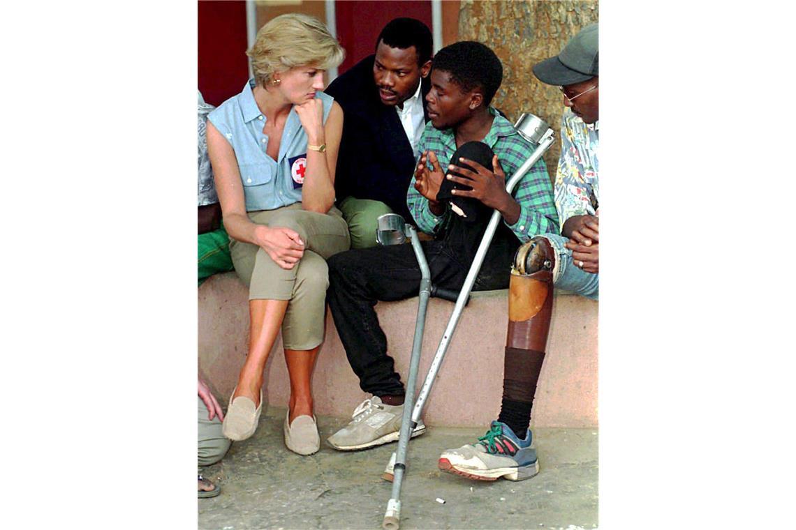 1997 hört Diana bei einem Besuch in einer orthopädischen Klinik in Luanda, Angola, ehemaligen Soldaten zu, die während des 20-jährigen Bürgerkriegs Opfer von Landminenexplosionen geworden sind.