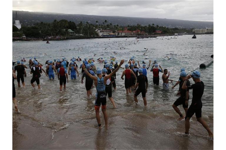 2019: Athleten stehen im Wasser der Kailia Bay für den Schwimmteil des Triathlons. Foto: Marco Garcia/FRE 132414 AP/dpa