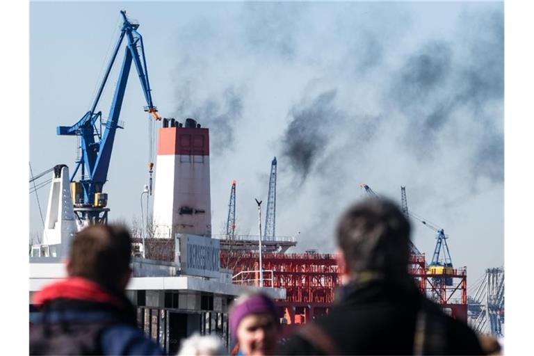 Abgase des Dieselantriebs entsteigen dem Schornstein eines Containerschiffes in Hamburg. Foto: Markus Scholz/dpa