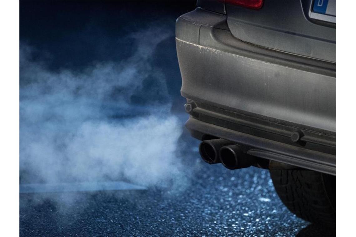Abgase kommen aus dem Auspuff eines Autos. Daimler und Volkswagen sind einer Studie zufolge noch nicht auf Kurs, die gültigen CO2-Grenzwerte einzuhalten. (Symbolbild). Foto: Marijan Murat/dpa