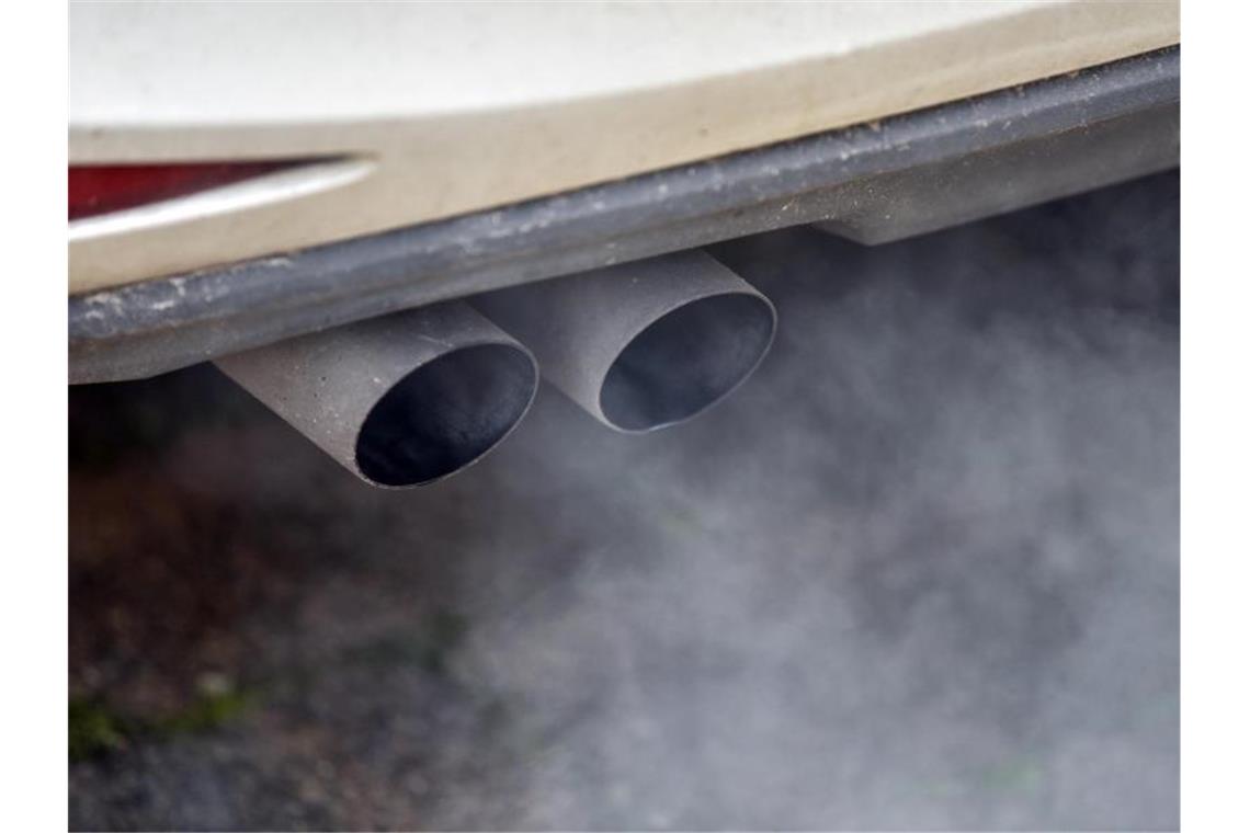 Daimler: Neuwagen bis 2039 ohne CO2-Ausstoß Abgase kommen aus einem Auspuff. Foto: Patrick Pleul/Archivbild