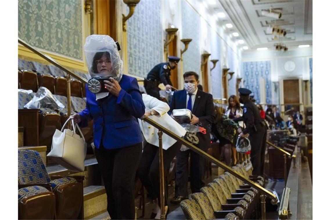 Abgeordnete suchen auf der Tribüne des Repräsentantenhauses Schutz. Foto: Andrew Harnik/AP/dpa