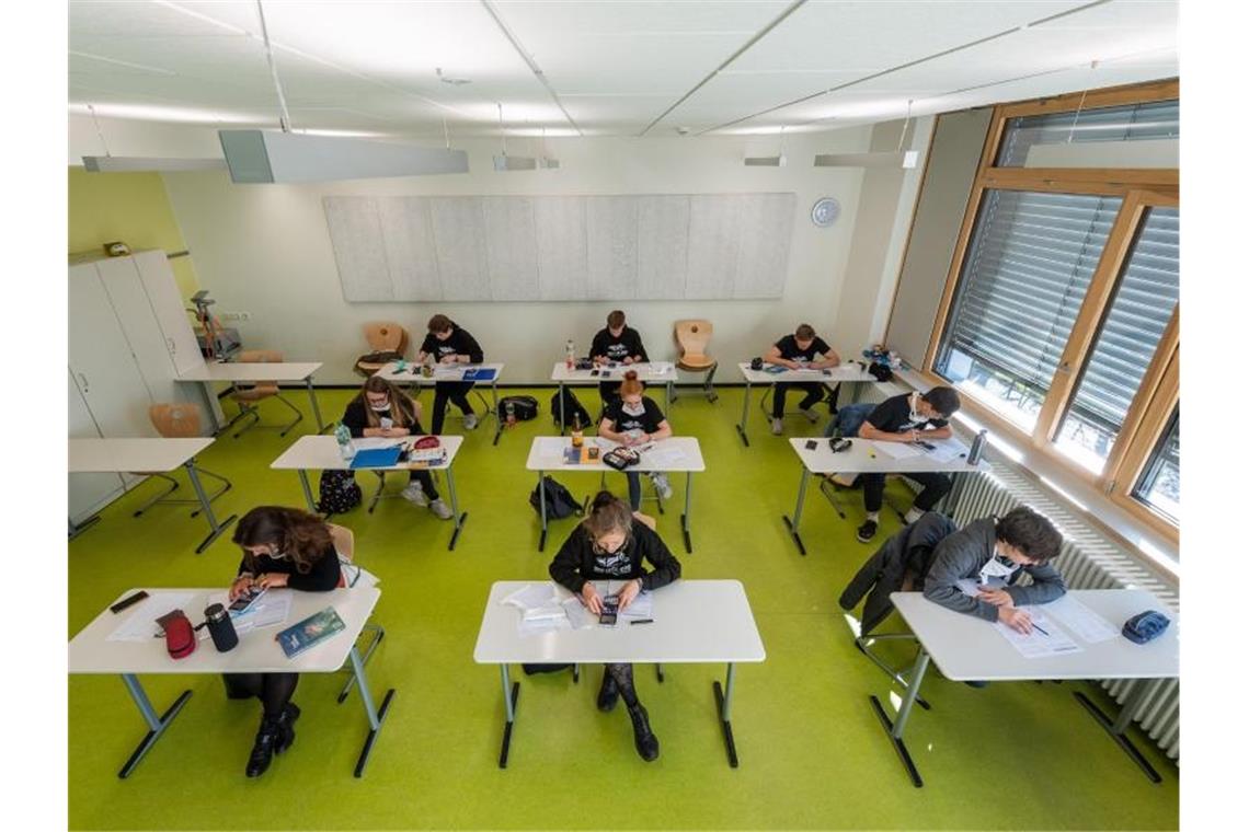 Abiturienten am Gymnasium Dresden Klotzsche sitzen mit Abstand und Mundschutz in einem Klassenzimmer. Foto: Robert Michael/dpa-Zentralbild/dpa