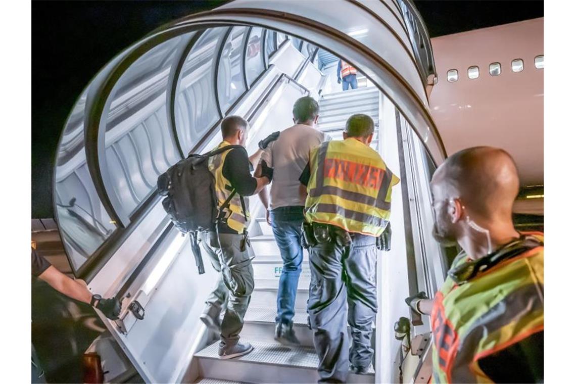 Abschiebung: Polizeibeamte begleiten einen Afghanen auf dem Flughafen Leipzig-Halle in ein Charterflugzeug. Foto: Michael Kappeler/dpa