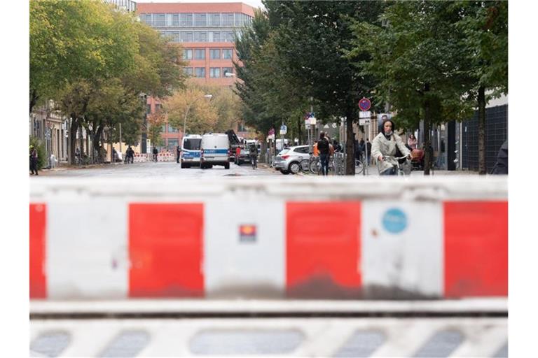 Absperrgitter und Einsatzfahrzeuge der Polizei stehen vor der geplanten Räumung der linken Bauwagensiedlung an der Köpenicker Straße. Foto: Paul Zinken/dpa
