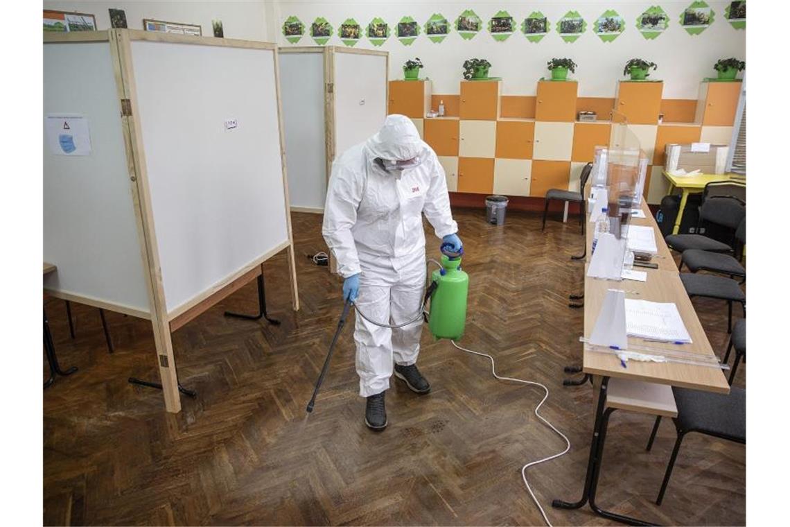 Abstimmung unter Corona-Bedingungen: Ein Arbeiter desinfiziert ein Wahllokal. Foto: Visar Kryeziu/AP/dpa