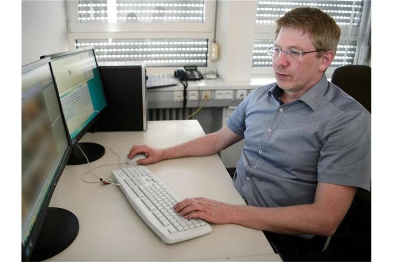 Achim Holzmann, Ermittler des Polizeipräsidiums Heilbronn im Bereich Kinderpornografie, sichtet Bildmaterial. Foto: Sina Schuldt/dpa