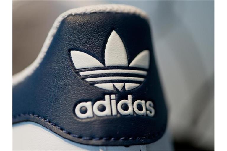 Adidas-Logo auf einem Sportschuh. Foto: picture alliance / Daniel Karmann/dpa