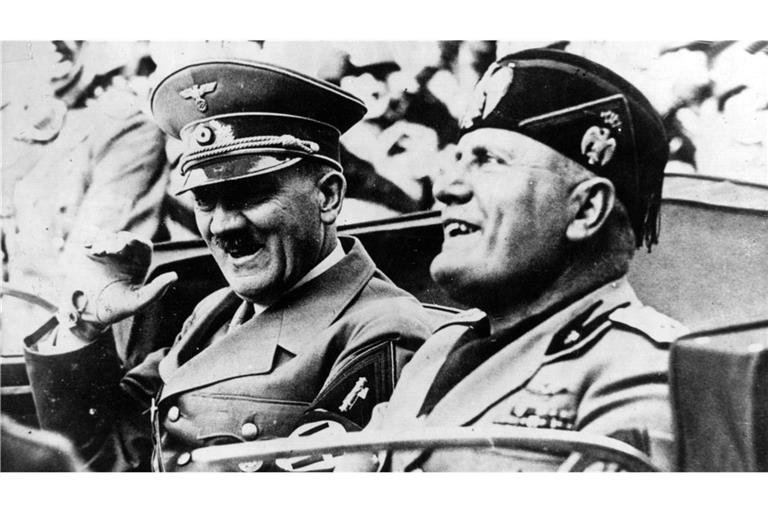 Adolf Hitler (li.) und der italienische Ministerpräsident und Duce Benito Mussolini (re.) fahren in einem offenen Wagen durch Florenz. Der Italien-Besuch des NS-Diktators vom 3. bis zum 9. Mai 1938 wurde zu einer Machtdemonstration des Faschismus.