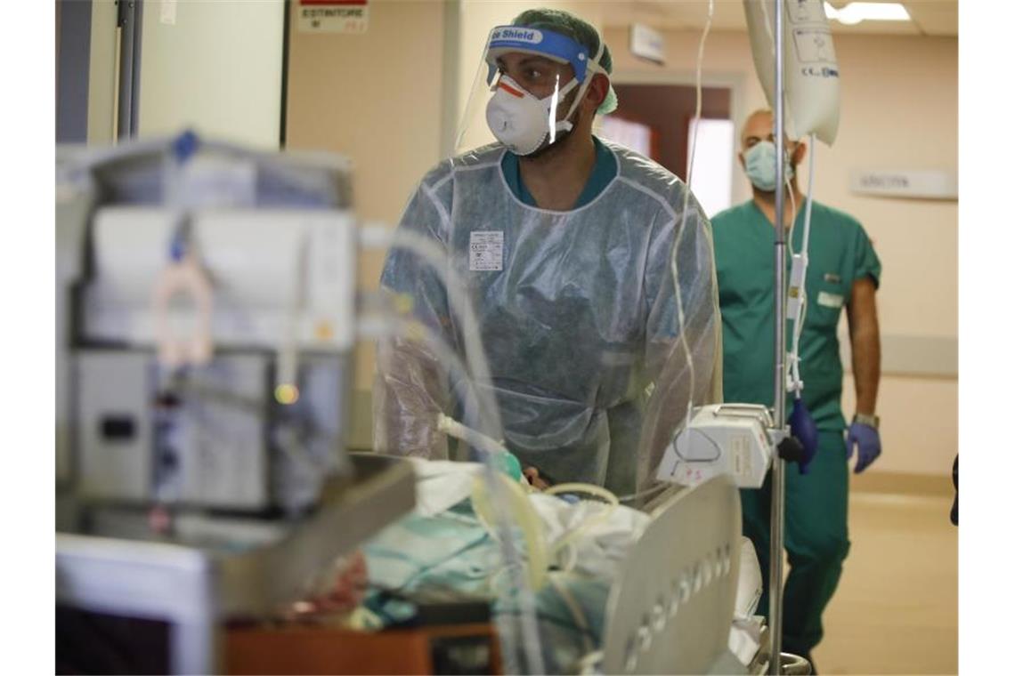 Ärzte tragen einen Corona-Patienten auf der Intensivstation des Circolo-Krankenhauses. Italien hat die Schwelle von einer Million registrierter Corona-Fälle überschritten. Foto: Luca Bruno/AP/dpa