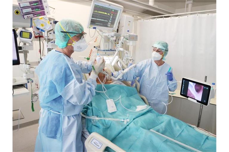 Ärzte und Pfleger betreuen einen Patienten auf der Covid-19-Intensivstation im SRH Waldklinikum in Gera. Foto: Bodo Schackow/dpa-Zentralbild/dpa