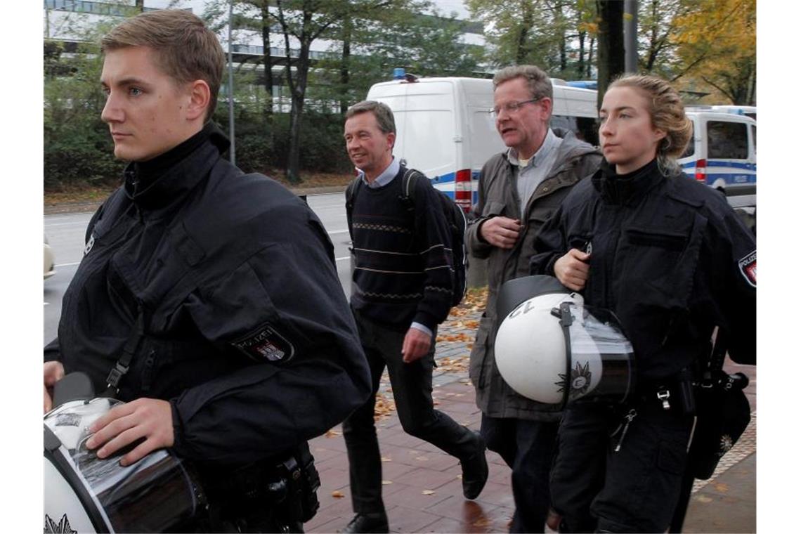AfD-Mitbegründer Bernd Lucke (2.v.l.) verlässt nach seiner durch massive Proteste gestörten Antrittsvorlesung von Polizisten geschützt den Campus der Universität Hamburg. Foto: Markus Scholz/dpa