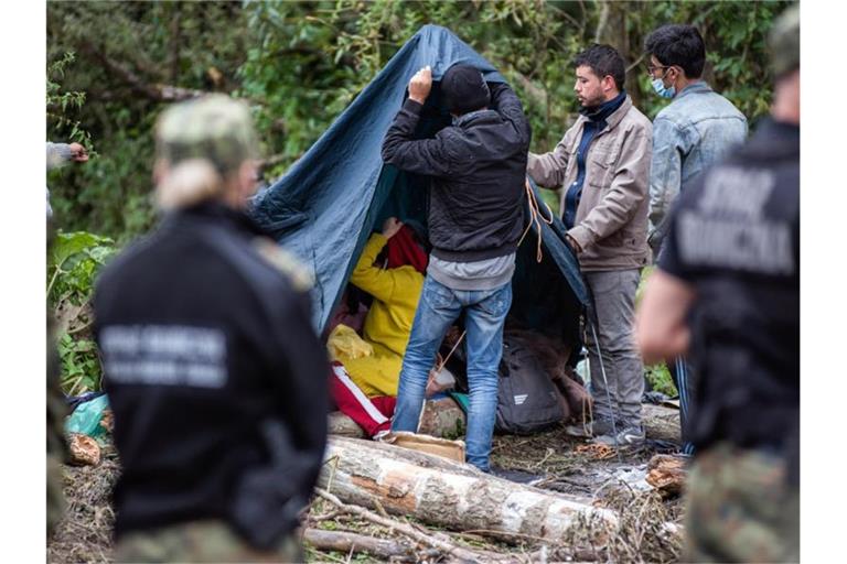 Afghanische Flüchtlinge bauen in einem behelfsmäßigen Lager an der Grenze zwischen Polen und Belarus Zelte auf. Foto: Attila Husejnow/SOPA Images via ZUMA Press Wire/dpa