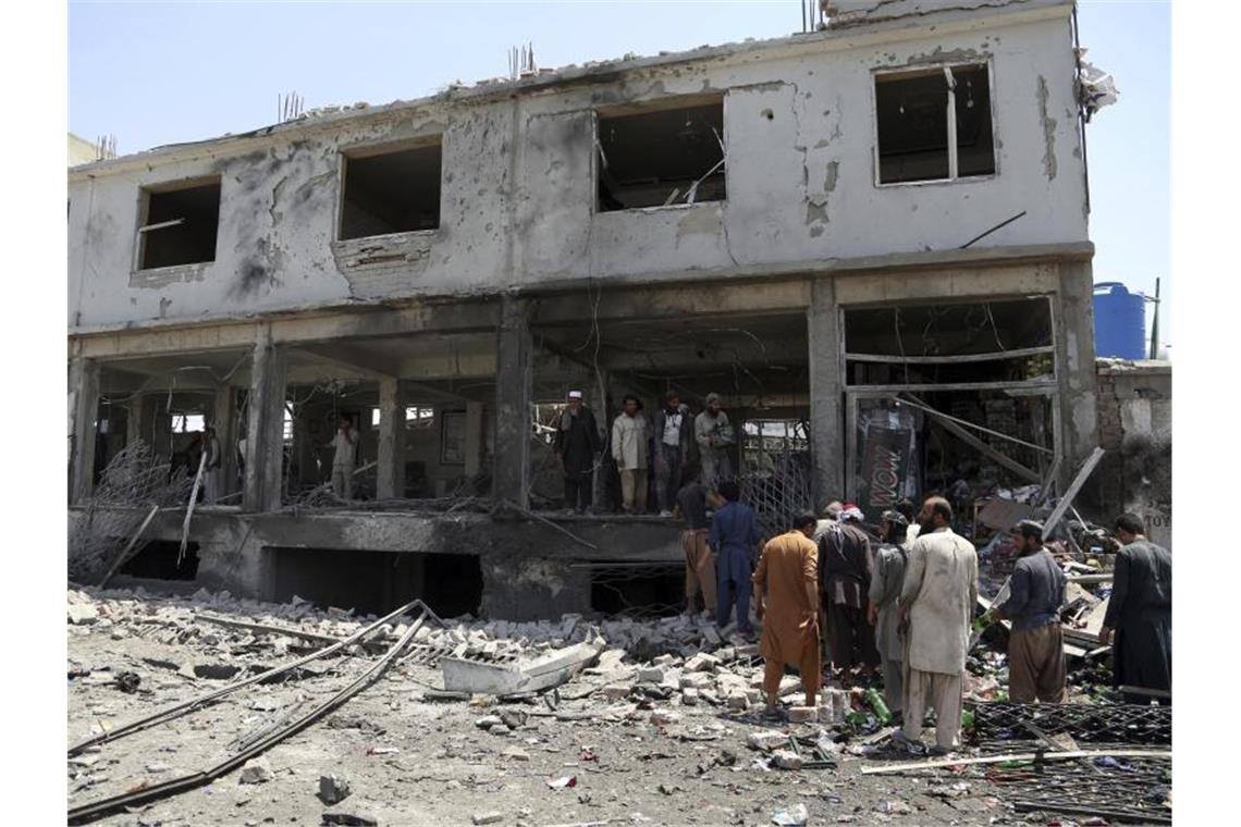 Mehr als 50 Tote bei Gewaltwelle in Afghanistan Afghanische Männer suchen nach dem Anschlag nach persönlichen Gegenständen in ihren Läden. Foto: Rahmat Gul/AP