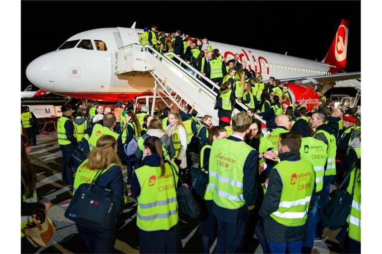 Air-Berlin-Mitarbeiter nach der Landung der letzten Maschine auf dem Flughafen Berlin-Tegel. Foto: Gregor Fischer/dpa