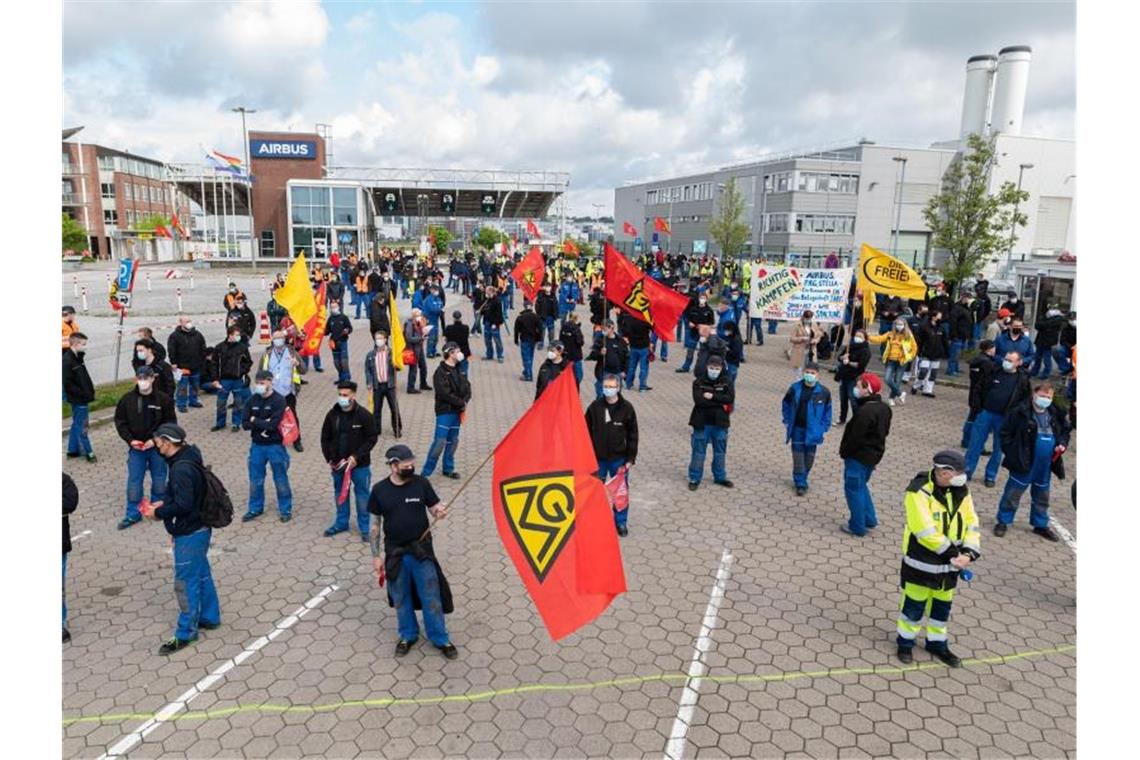 Airbus-Beschäftigte in Hamburg-Finkenwerder demonstrieren im Mai 2021 vor den Toren des Werksgeländes. Die Verhandlungen zwischen Airbus und der IG Metall über den seit Monaten umstrittenen Konzernumbau gehen in die zweite Runde. Foto: Daniel Reinhardt/dpa