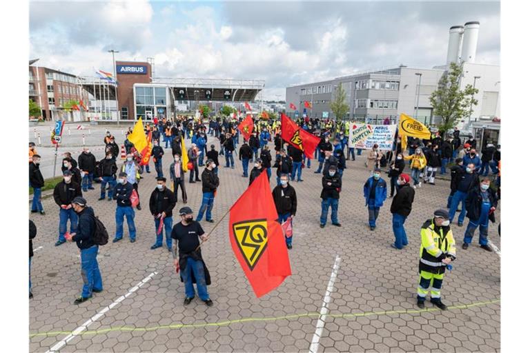 Airbus-Beschäftigte in Hamburg-Finkenwerder demonstrieren im Mai 2021 vor den Toren des Werksgeländes. Die Verhandlungen zwischen Airbus und der IG Metall über den seit Monaten umstrittenen Konzernumbau gehen in die zweite Runde. Foto: Daniel Reinhardt/dpa