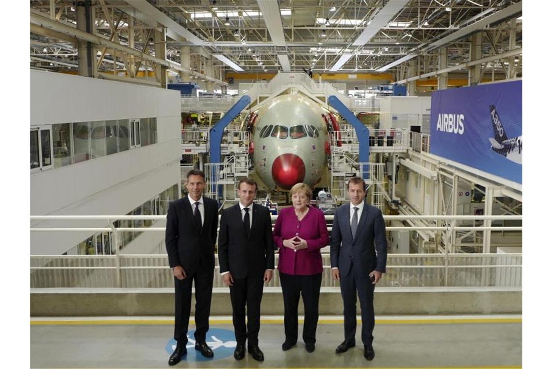 Airbus-Chef Guillaume Faury (r) empfängt Kanzlerin Merkel und Frankreichs Präsident Macron in Toulouse. Foto: Frederic Scheiber/AP/dpa