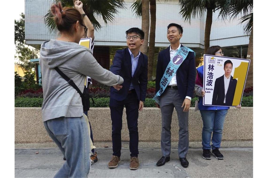 Hongkong: Demokratie-Lager liegt bei Bezirkswahlen vorn Aktivist Joshua Wong (2.v.l.) gilt im Ausland als das Gesicht der Proteste in Hongkong, ist anders als Kelvin Lam (2.v.r.) aber nicht als Kandidat für die Wahlen zugelassen. Foto: Vincent Yu/AP/dpa