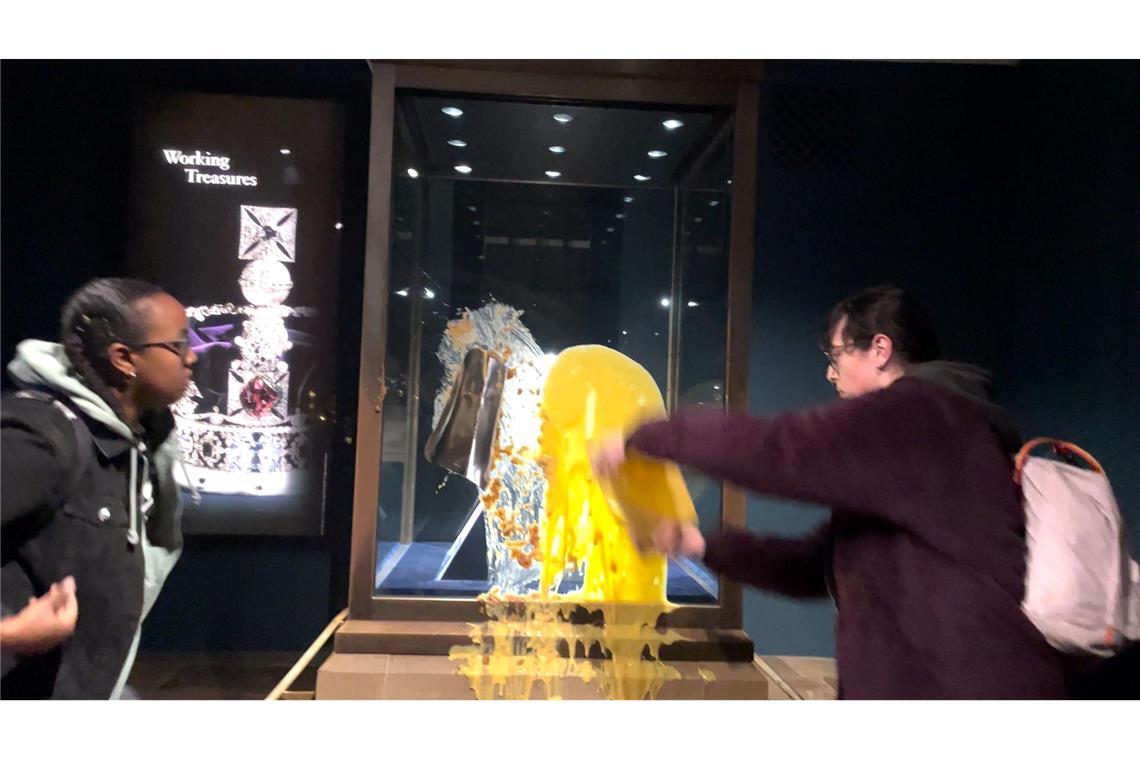 Aktivisten beschmieren die Vitrine, in der die Krone ist.