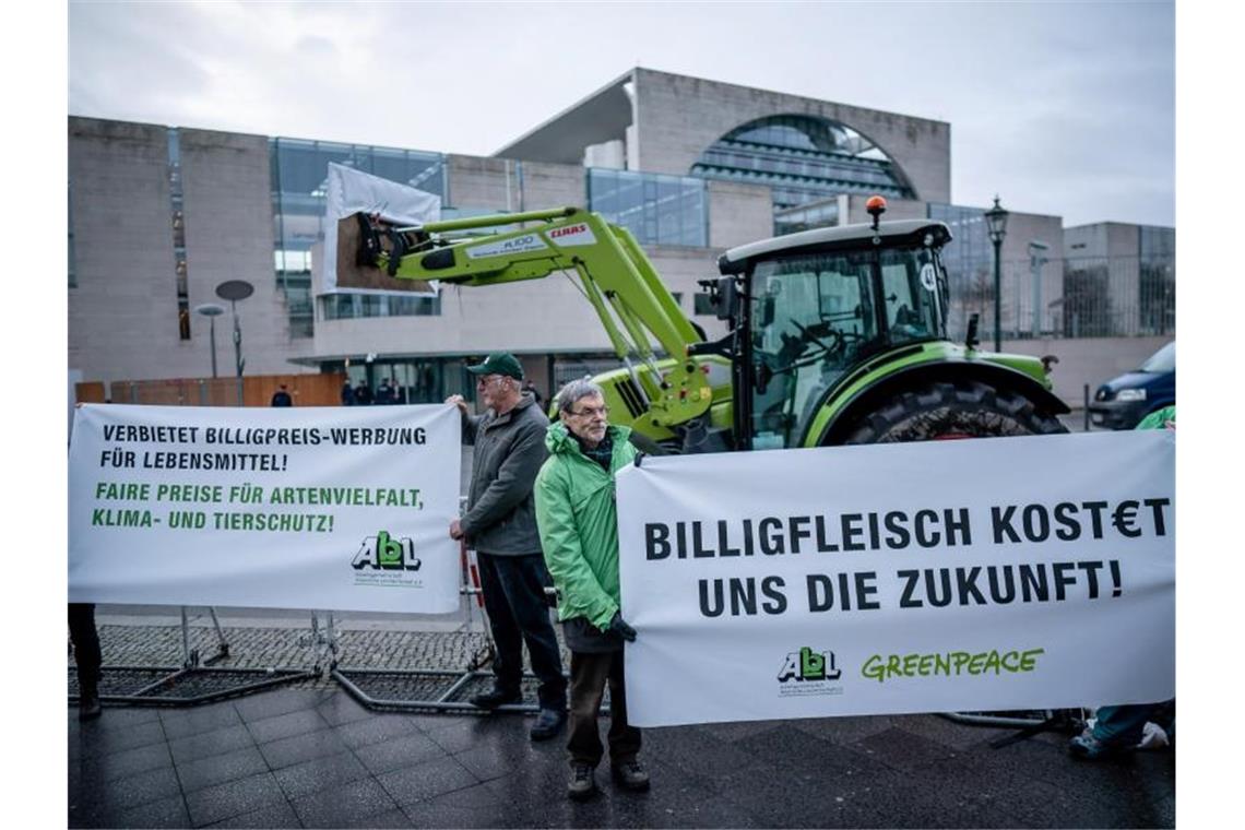 Aktivisten der „Arbeitsgemeinschaft bäuerliche Landwirtschaft“ und der Umweltschutzorganisation Greenpeace stehen mit Transparenten vor dem Kanzleramt. Foto: Michael Kappeler/dpa
