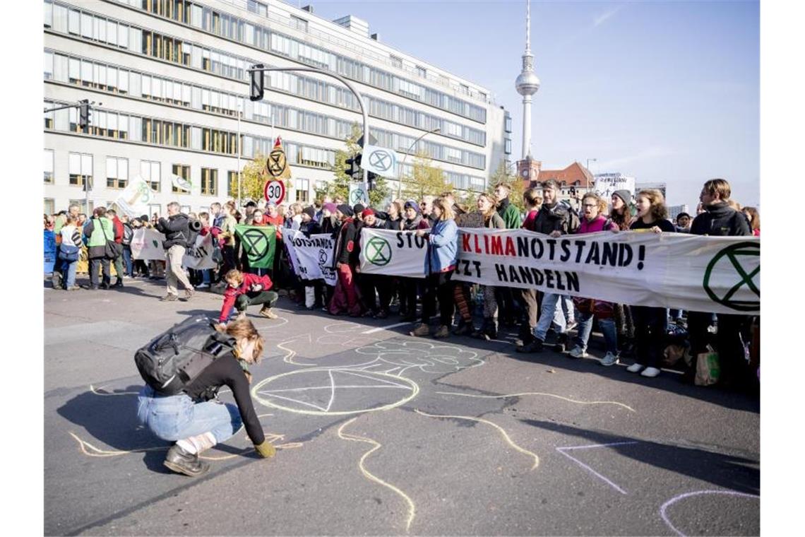 Aktivisten der Bewegung „Extinction Rebellion“ blockieren den Mühlendamm im Zentrum von Berlin. Foto: Christoph Soeder/dpa