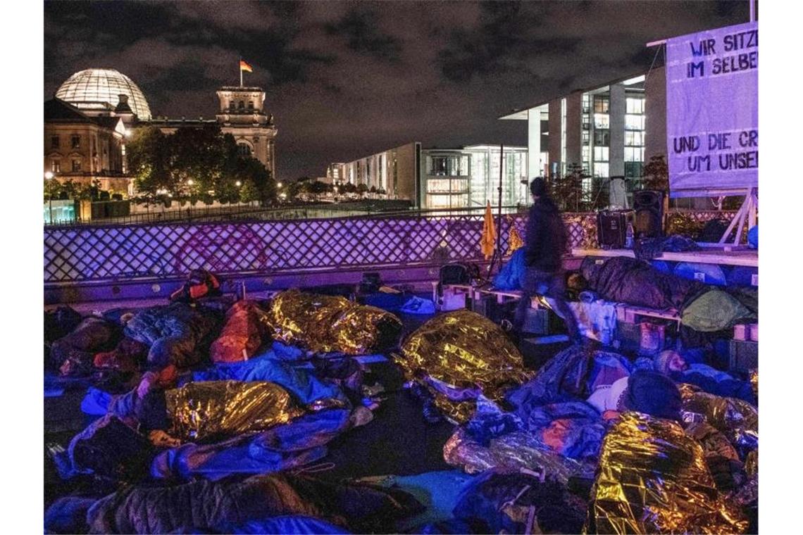 Aktivisten der Umweltbewegung „Extinction Rebellion“ besetzen die Marschallbrücke in Berlin, im Hintergrund ist der Reichstag zu sehen. Foto: Paul Zinken/dpa