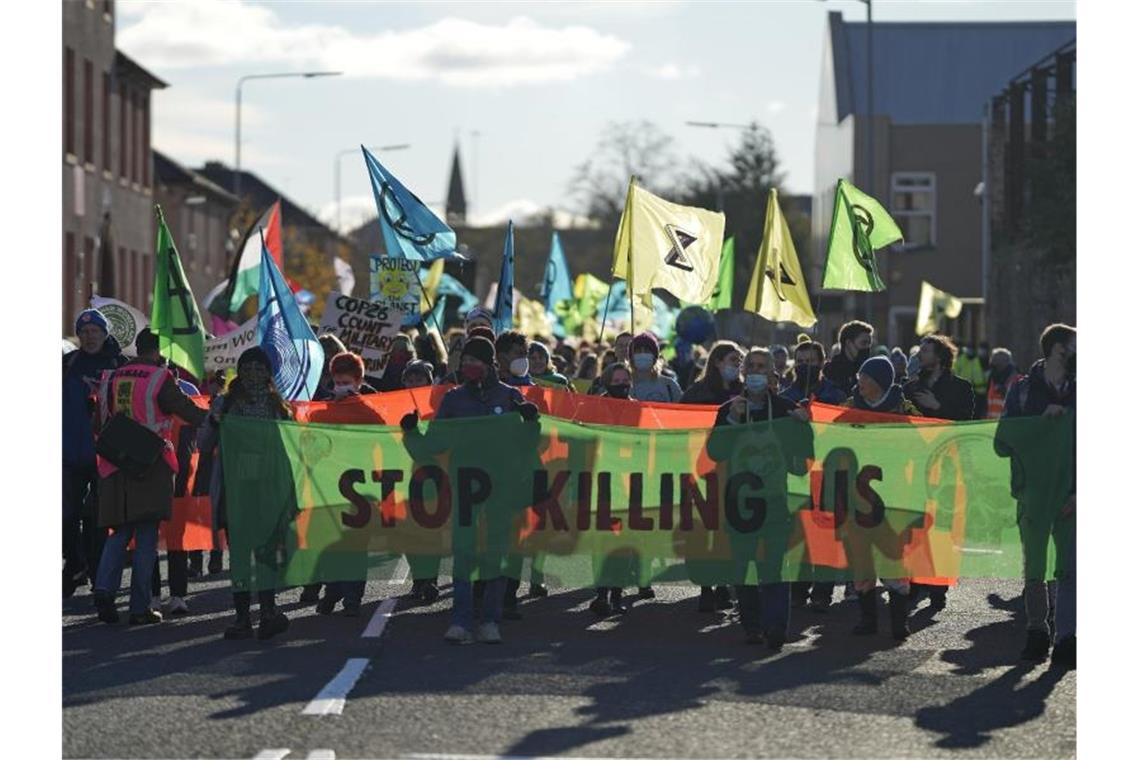 „Kein Blabla mehr“: Tausende bei Klimaprotest in Glasgow Aktivisten der Umweltschutz-Organisation Extinction Rebellion tragen bei einer Demonstration parallel zum Weltklimagipfel COP26 ein Transparent mit der Aufschrift „Stop Killing Us“ (Hört auf, uns zu töten). Foto: Alastair Grant/AP/dpa