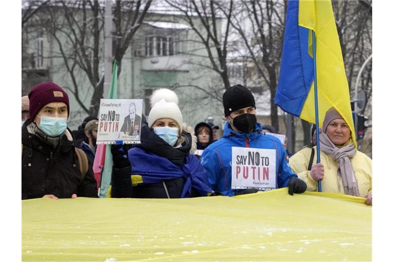 Aktivisten halten Plakate und Nationalflaggen während einer „Say-NO-to-Putin“-Kundgebung im ukrainischen Kiew. Foto: Efrem Lukatsky/AP/dpa