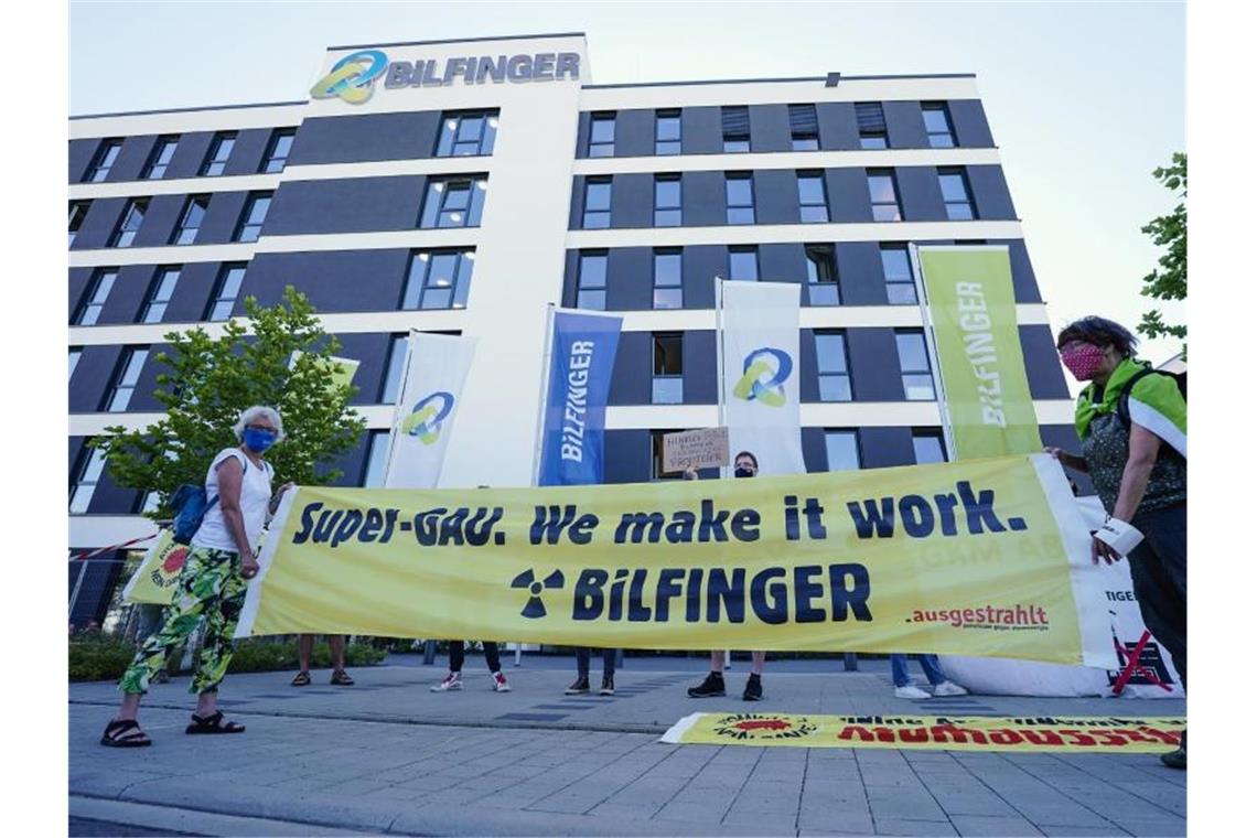 Aktivisten halten vor der Bilfinger-Konzernzentrale ein Transparent in den Händen. Foto: Uwe Anspach/dpa
