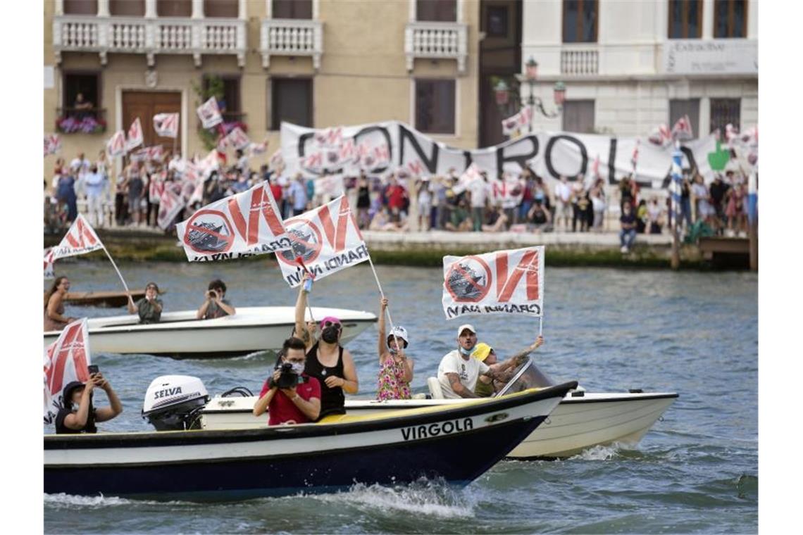 Kreuzfahrtschiff legt unter Protesten in Venedig ab Aktivisten protestieren gegen den Start des ersten Kreuzfahrtschiffs in Venedig. Foto: Antonio Calanni/AP/dpa