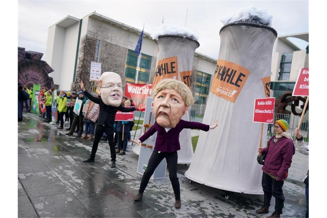 Aktivisten protestieren verkleidet als Angela Merkel und Peter Altmaier vor dem Bundeskanzleramt gegen den Zeitplan für den Kohleausstieg. Foto: Kay Nietfeld/dpa