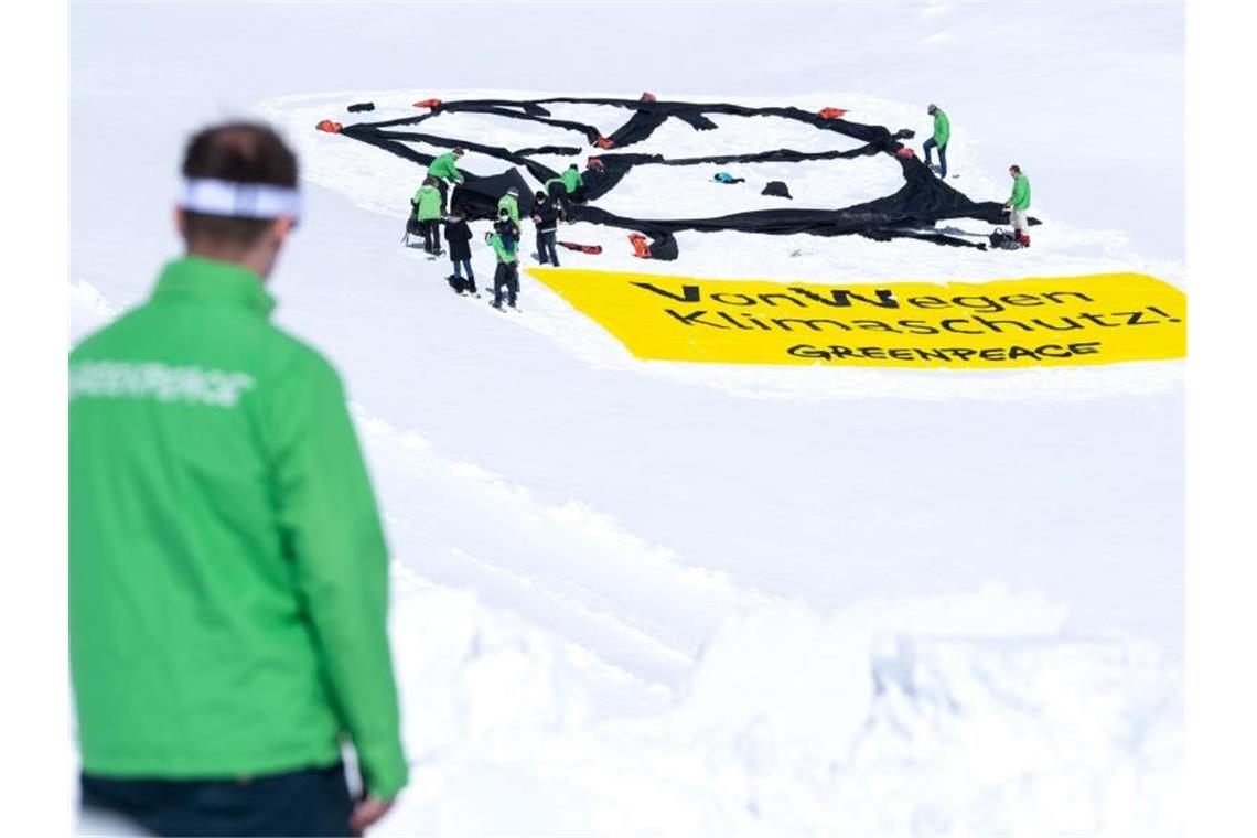 Aktivisten von Greenpeace haben auf dem Gletscher an der Zugspitze ein VW-Logo und ein Banner mit der Aufschrift "VonWegen Klimaschutz" ausgerollt. Foto: Sven Hoppe/dpa
