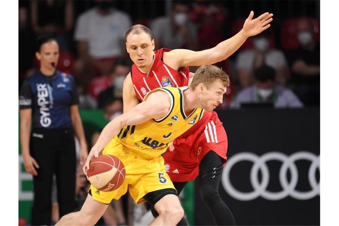 Alba kämpft sich zum Basketball-Meistertitel Alba-Kapitän Niels Giffey (vorne) im Duell mit Bayerns Robin Amaize. Foto: Tobias Hase/dpa