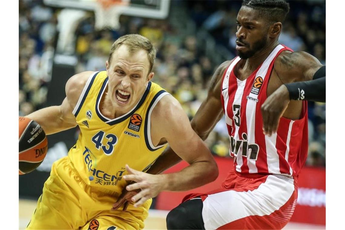 Alba Berlin ohne Chance gegen Olympiakos Piräus Albas Luke Sikma (l) kämpft sich durch die Abwehr von Olympiakos Piräus. Foto: Andreas Gora/dpa
