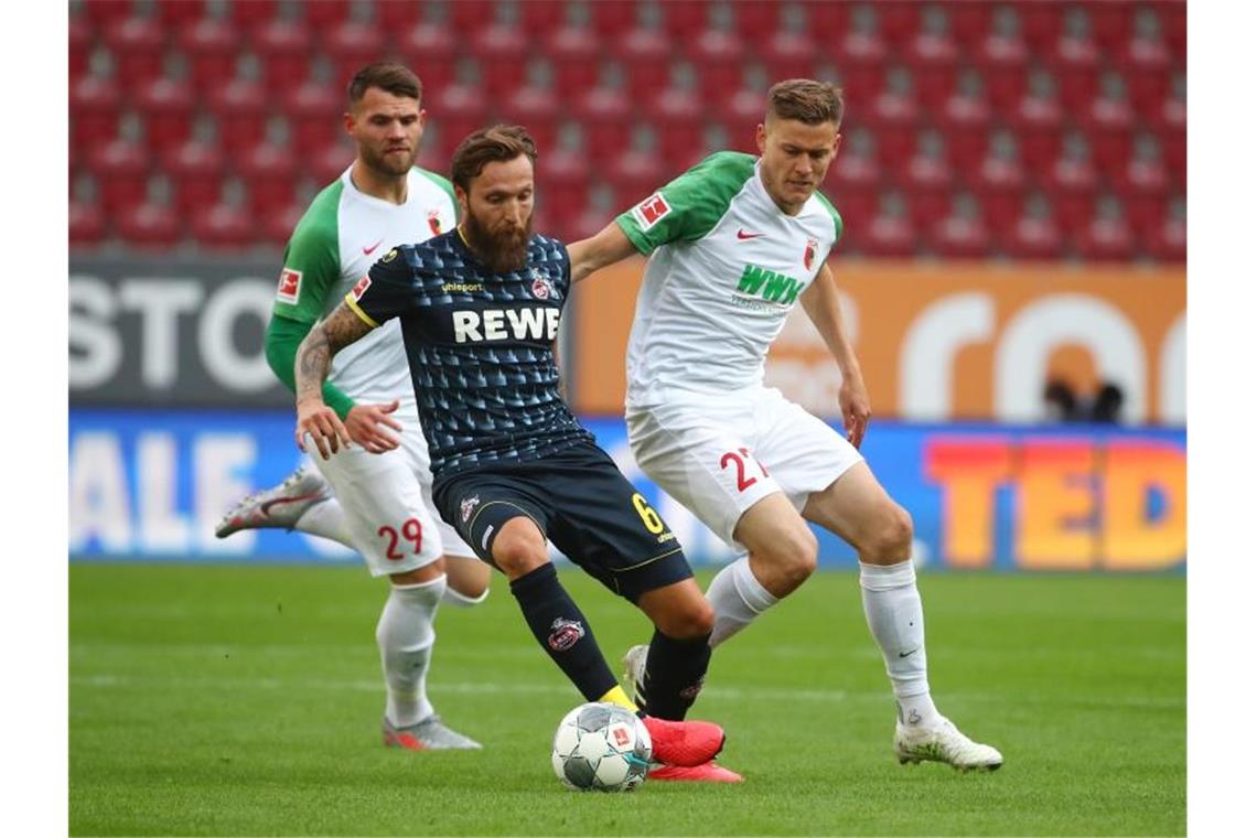 Alfred Finnbogason (r) vom FC Augsburg in Aktion gegen Marco Höger (M) vom 1. FC Köln. Foto: Michael Dalder/Reuters-Pool/dpa