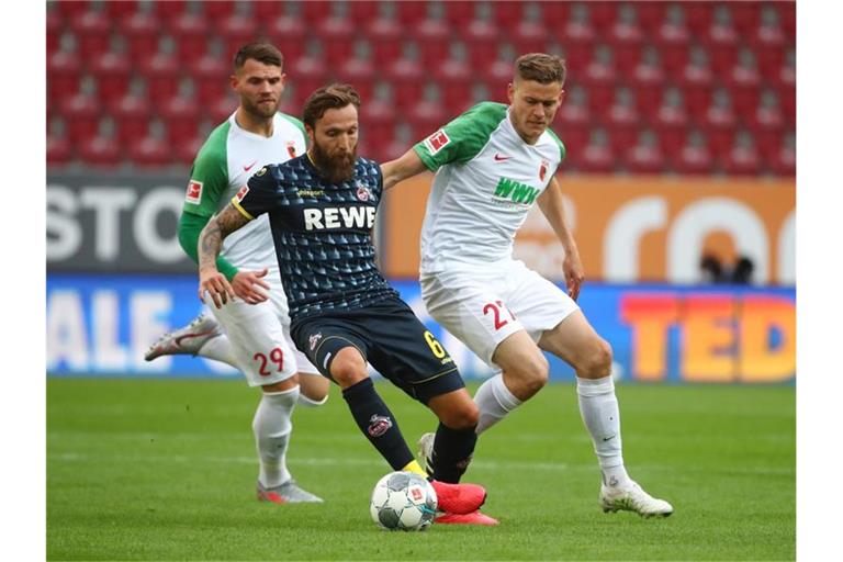 Alfred Finnbogason (r) vom FC Augsburg in Aktion gegen Marco Höger (M) vom 1. FC Köln. Foto: Michael Dalder/Reuters-Pool/dpa