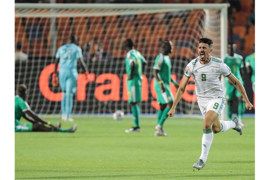 Algerien feiert Sieg im Afrika-Cup - Schalkes Sané am Boden Algeriens Baghdad Bounedjah jubelt über den Siegtreffer im Finale des Afrika Cups. Foto: Oliver Weiken