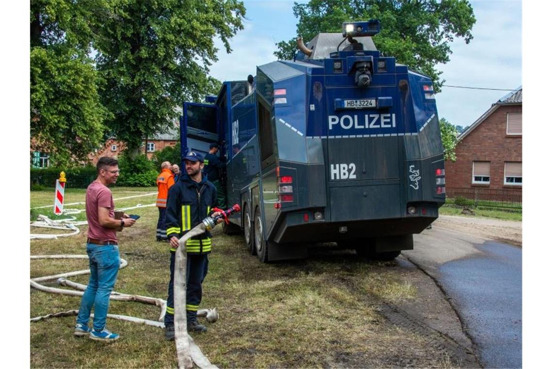 Alles, was löschen kann, ist im Einsatz: Ein Wasserwerfer der Polizei wird im evakuierten Ort Alt Jabel mit Löschwasser aufgetankt. Foto: Jens Büttner