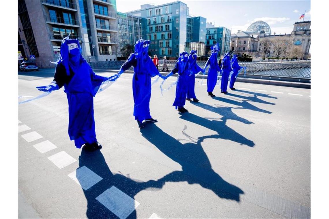 Als „Blue Rebels“ verkleidete Menschen bei einer Performance der Umweltschutzbewegung „Extinction Rebellion“ im März 2021 auf der Marschallbrücke in Berlin. Foto: Christoph Soeder/dpa