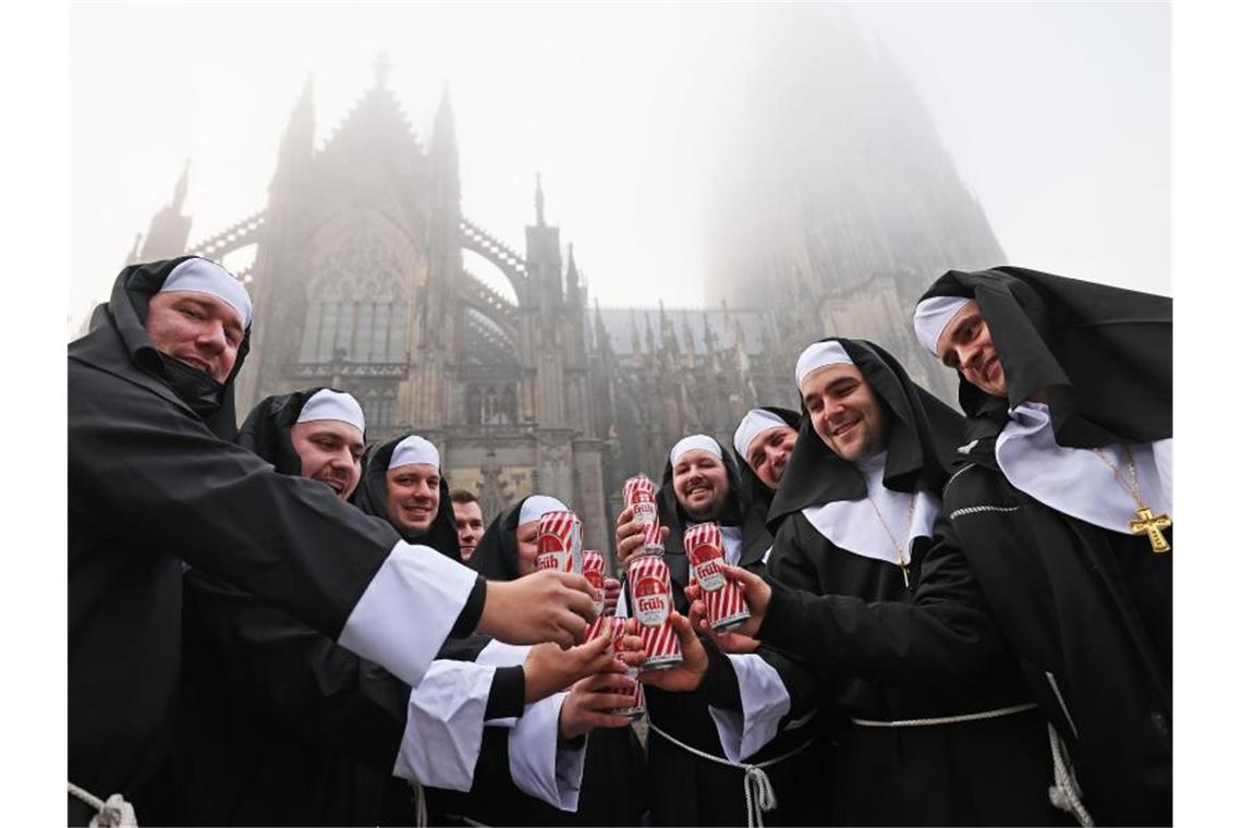 Riesenandrang zum Karnevalsauftakt in Köln Als Nonnen verkleidete Karnevalisten feiern vor dem Dom in Köln. Foto: Oliver Berg/dpa