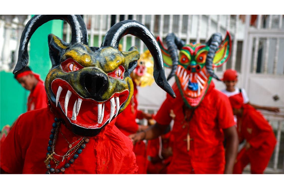 Als Teufel verkleidete Männer nehmen in Venezuela an einem traditionellen Volksfest zu Fronleichnam teil.