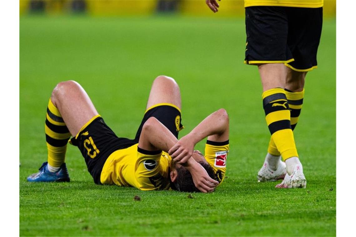 „Als wäre der ein oder andere mit dem Kopf bereits im Urlaub“: Dortmunds Raphael Guerreiro (l) liegt nach dem 0:2 gegen Mainz auf dem Rasen. Foto: Guido Kirchner/dpa-pool/dpa