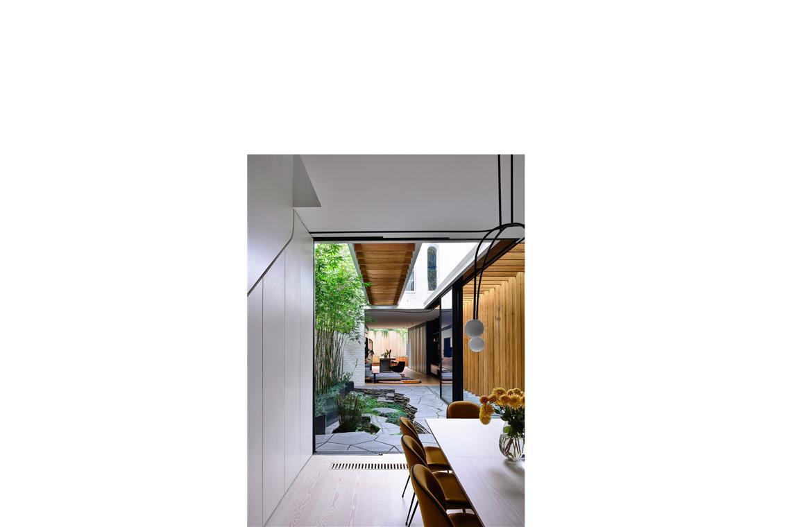 Extravagante Villen, die auch Gemüse produzieren Altes bewahren hilft CO2 sparen: Blick ins „Fitzroy Bridge House“ in einem Vorort von Melbourne, Australien, entworfen für eine junge Familie von von Matt Gibson Architecture + Design. Die alte Fassade eines Hauses blieb erhalten und durch eine Glasbodenbrücke mit dem Neubau verbunden. Alte Ziegel wurden wieder verwendet.
